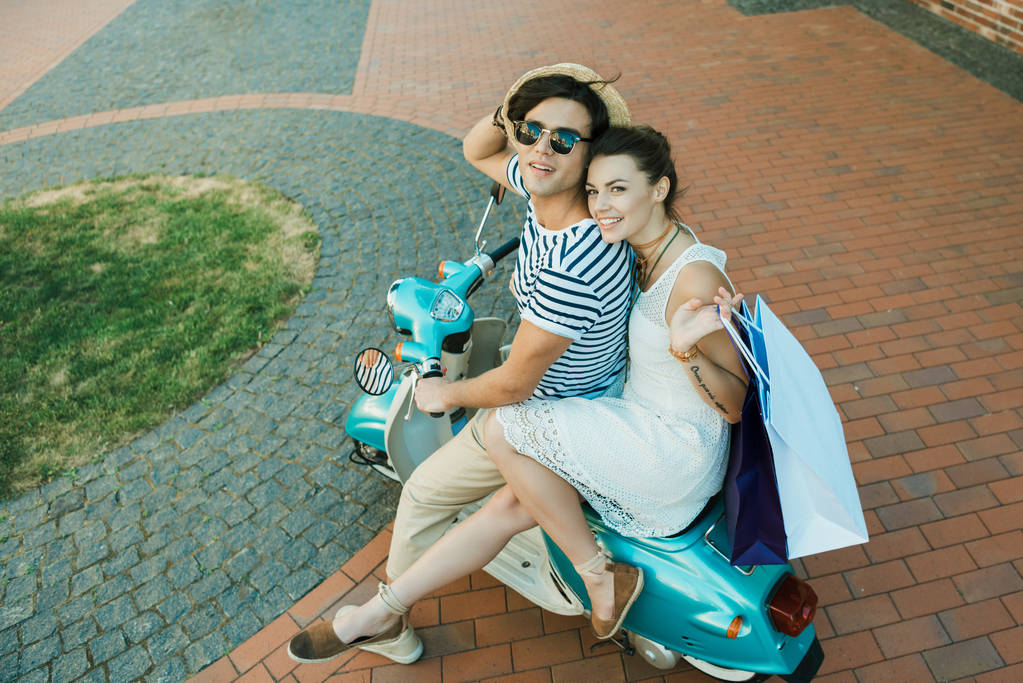 joven sonriente pareja cabalgando en scooter
 - Foto, Imagen