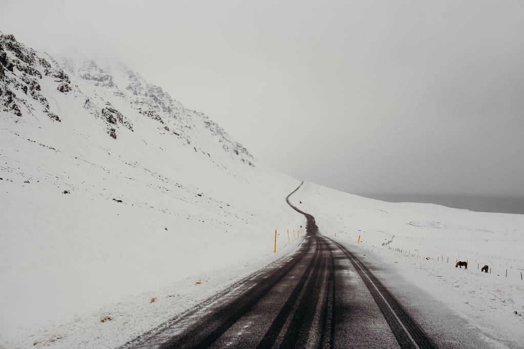 besneeuwde weg in mistige bergen - Foto, afbeelding