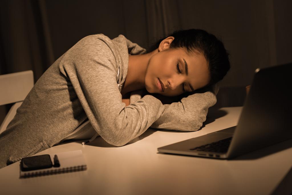 ノート パソコンの近くのテーブルで寝て疲れている女性 - 写真・画像