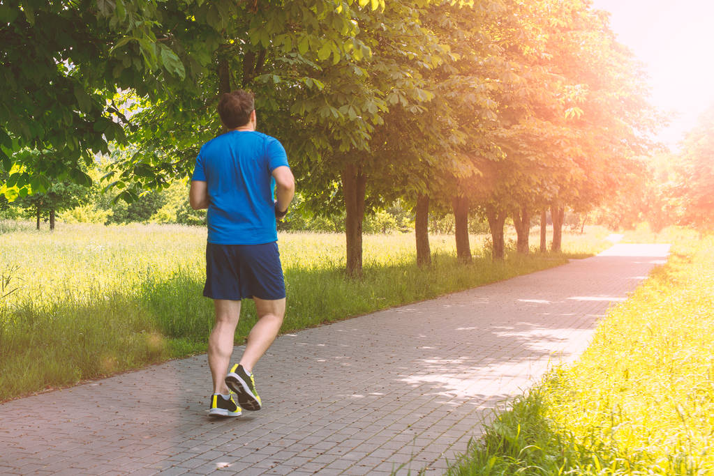 A man is running in the park on a sunny day - Photo, Image