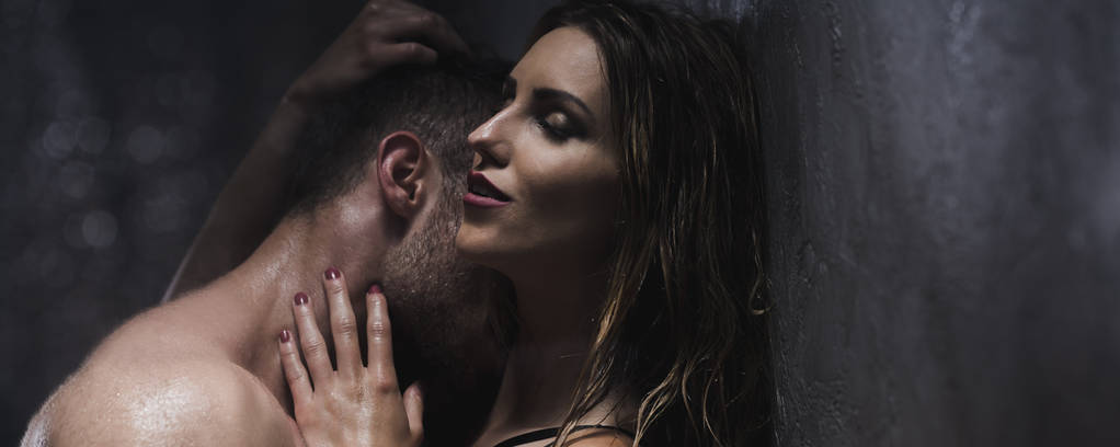 Mies intohimoisesti suutelee naisten kaulaa suihkussa
 - Valokuva, kuva