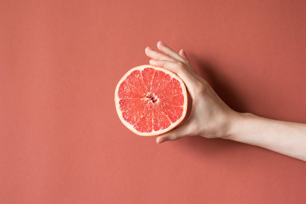 Mains d'une jeune femme tenant un pamplemousse rouge. concept d'alimentation saine - Photo, image