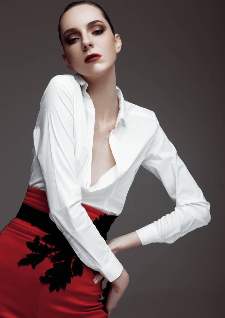 Kırmızı pantolon ve beyaz gömlek giymiş bir modeldir - Fotoğraf, Görsel