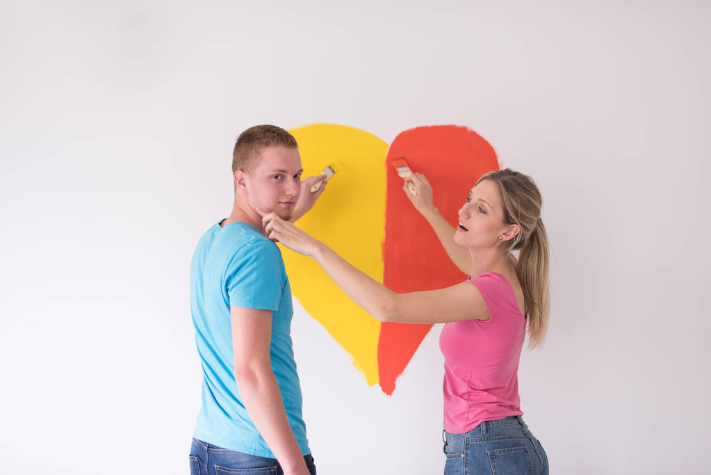 pareja están pintando un corazón en la pared
 - Foto, imagen