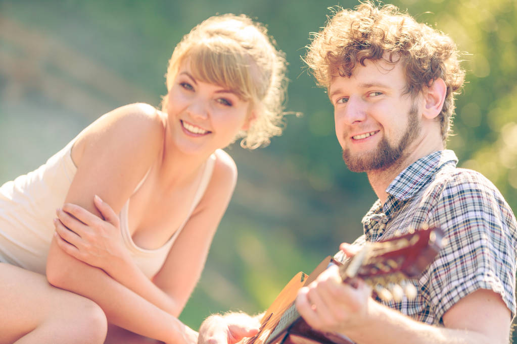 joven pareja camping jugando guitarra al aire libre
 - Foto, Imagen