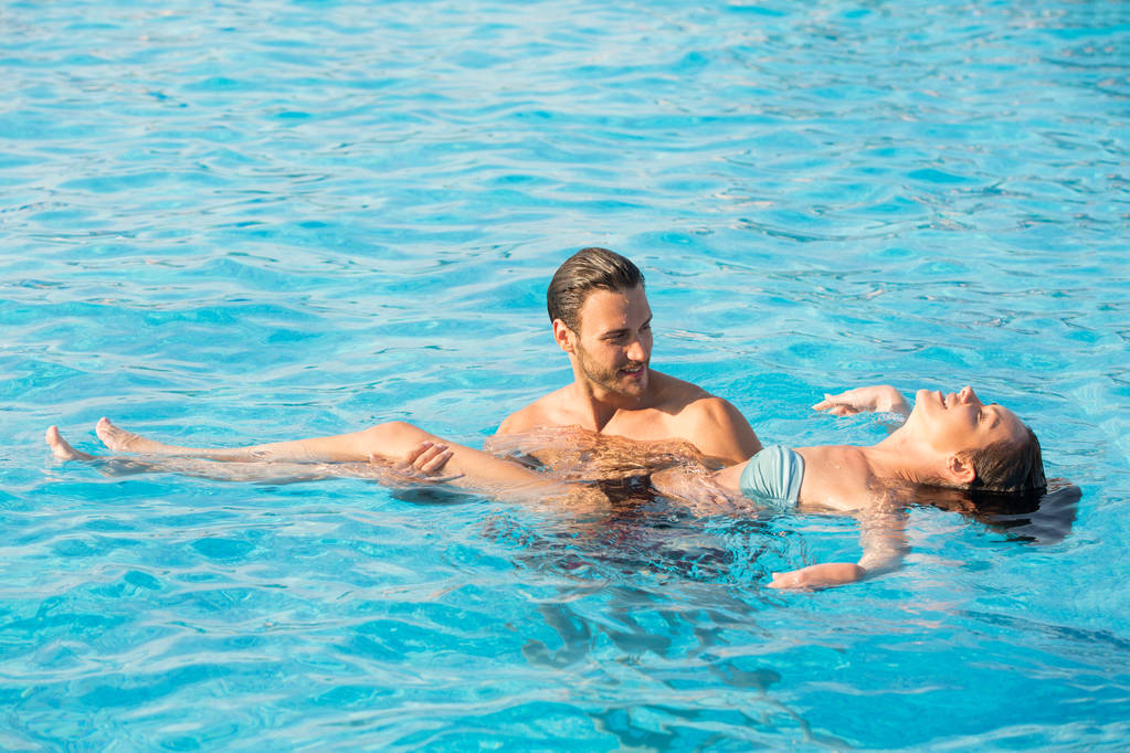 Affectionate couple in swimming pool  - Photo, Image