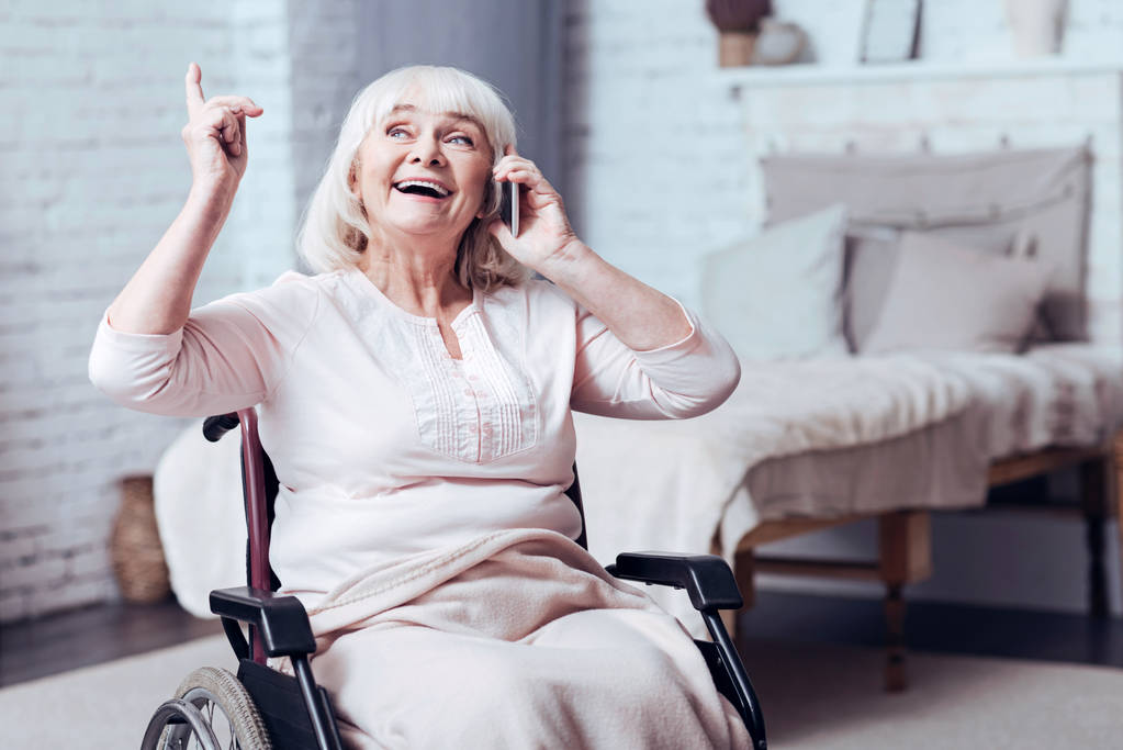 Mozgáskorlátozottak pozitív éves nő beszél szúró telefon-otthon - Fotó, kép