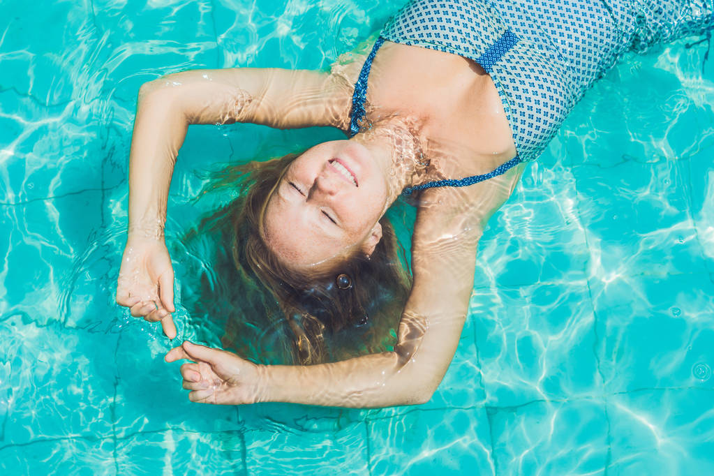 Νεαρή γυναίκα επιπλέουν στην πισίνα - Φωτογραφία, εικόνα
