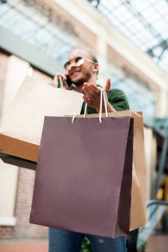 hombre con bolsas de compras en el centro comercial
  - Foto, imagen