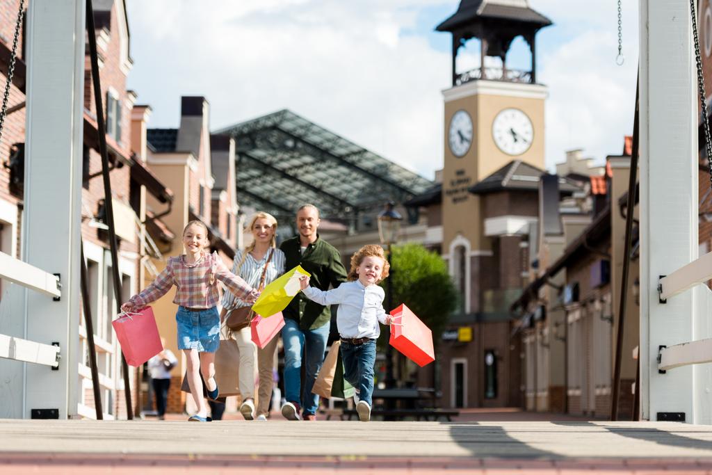 Familie läuft mit Einkaufstüten auf der Straße - Foto, Bild