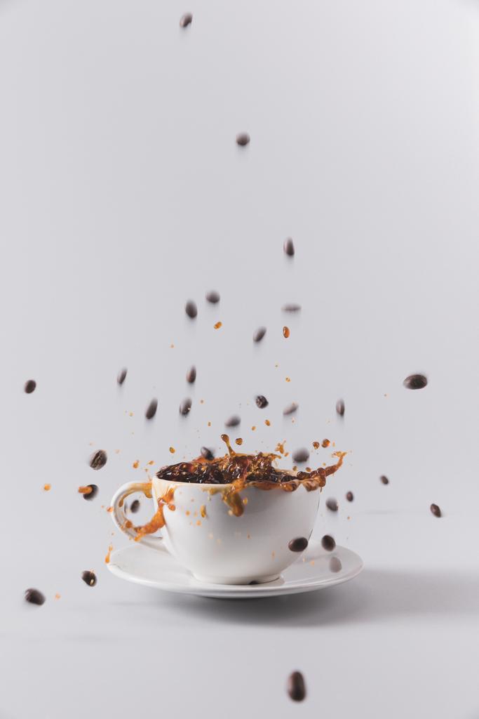 чашка кави з падаючими зернами кави
 - Фото, зображення