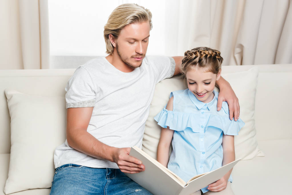 Отец и дочь читают книгу
 - Фото, изображение