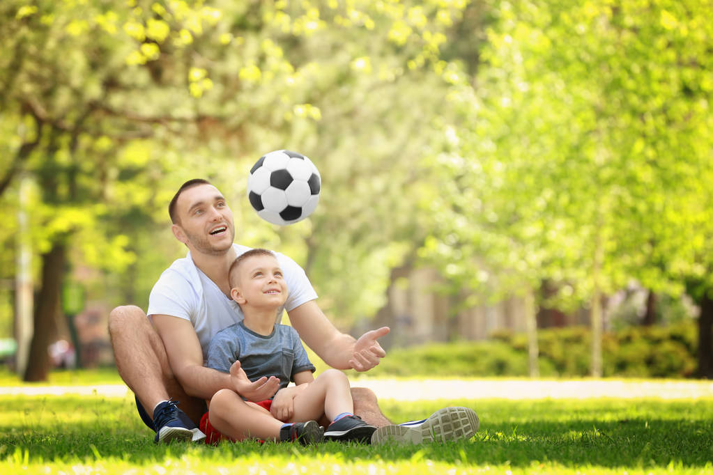 サッカーボールで遊ぶ父と息子  - 写真・画像