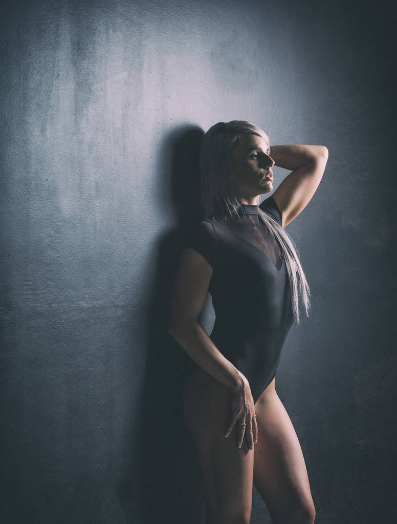Sexy female fitness model in a studio with dramatic lighting and - Photo, Image