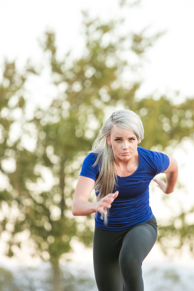 Sportlerin sprintet auf einer Tartanbahn - Foto, Bild