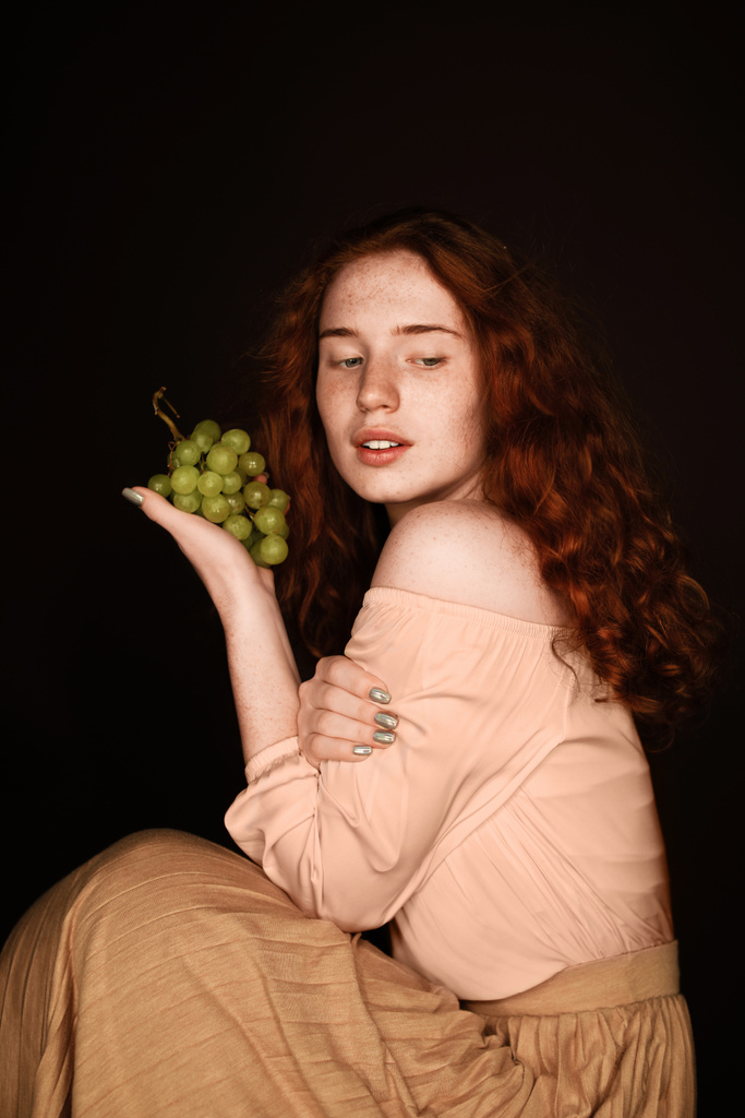 赤毛の女性がブドウでポーズ - 写真・画像