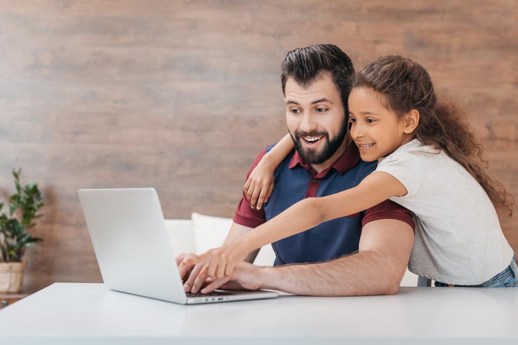 vader en dochter met laptop - Foto, afbeelding