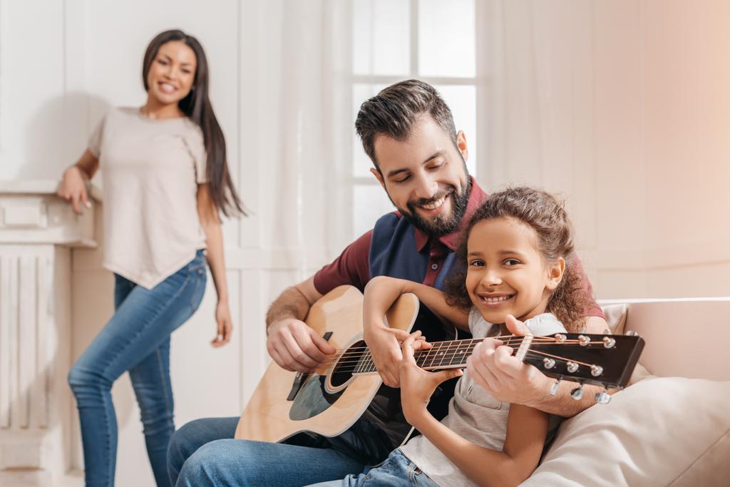 Perhe soittaa kitaraa
  - Valokuva, kuva