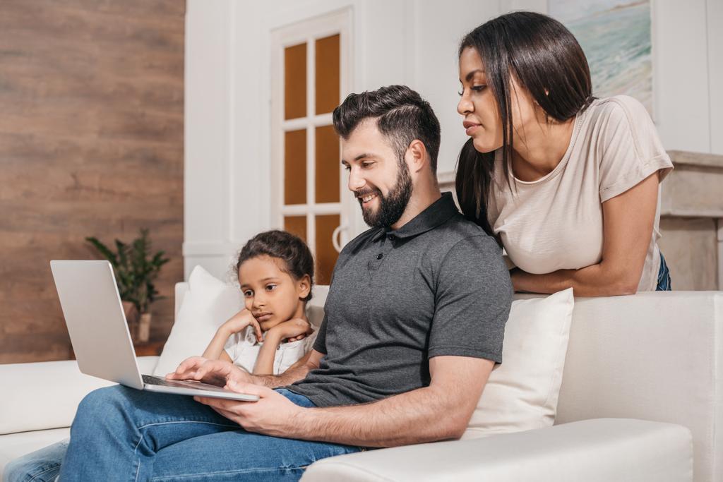 perhe kannettavan tietokoneen kotona
 - Valokuva, kuva