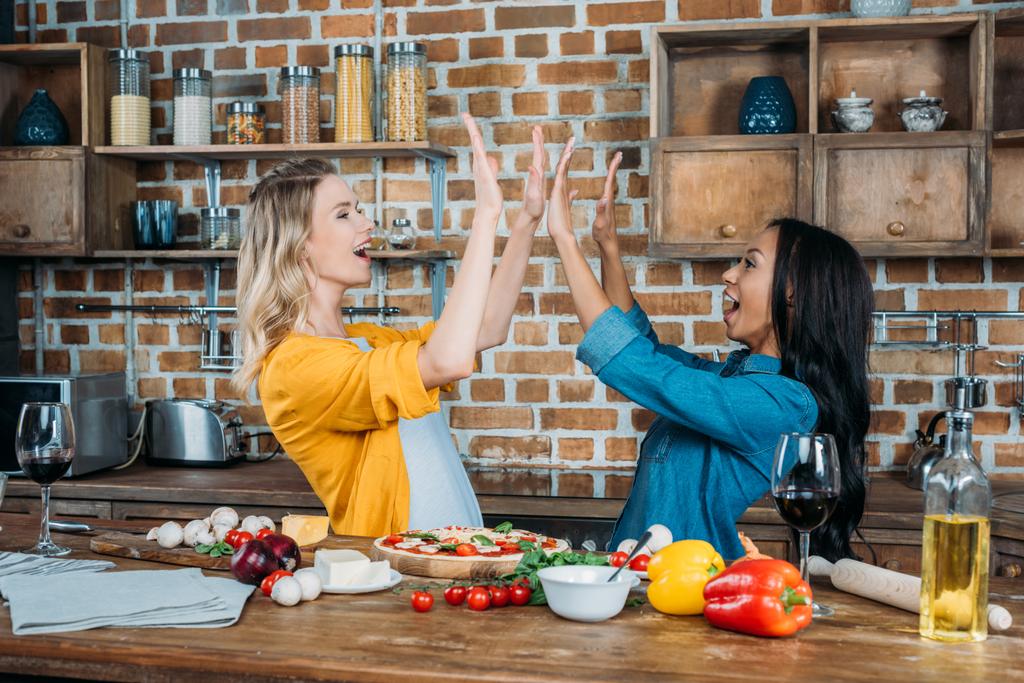 mulheres com pizza na cozinha
  - Foto, Imagem