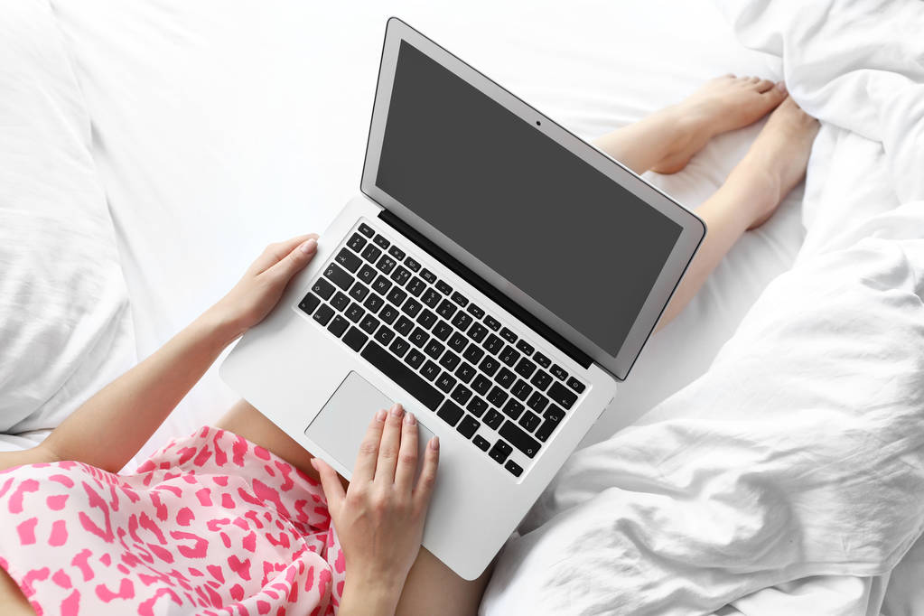 Laptop ile yatağa çalışan genç kadın - Fotoğraf, Görsel