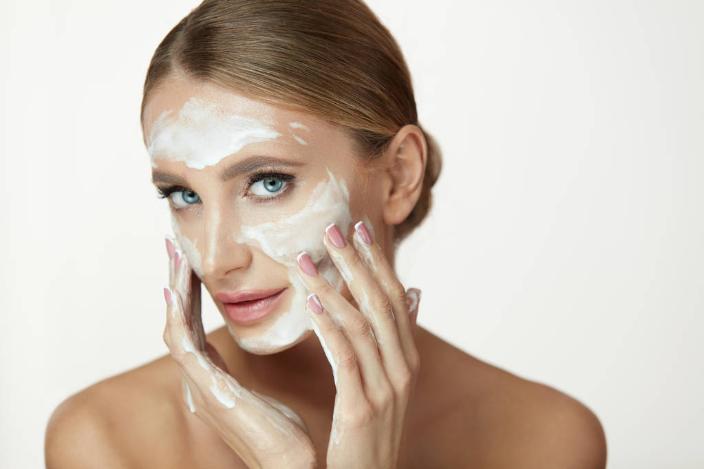 Lavaggio del viso. Applicazione del prodotto cosmetico femminile sul viso di bellezza
 - Foto, immagini