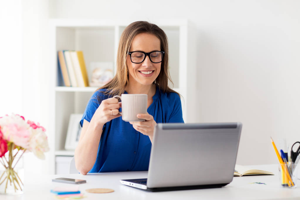 woman with laptop and coffee at home or office - Photo, Image
