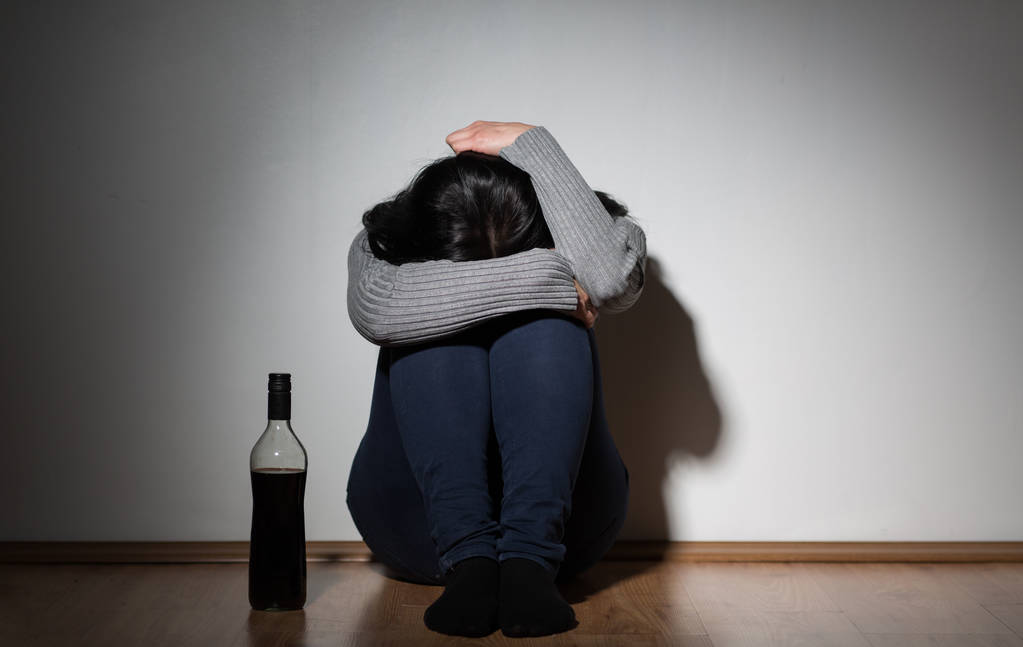 γυναίκα με μπουκάλι οινόπνευμα κλάμα στο σπίτι - Φωτογραφία, εικόνα