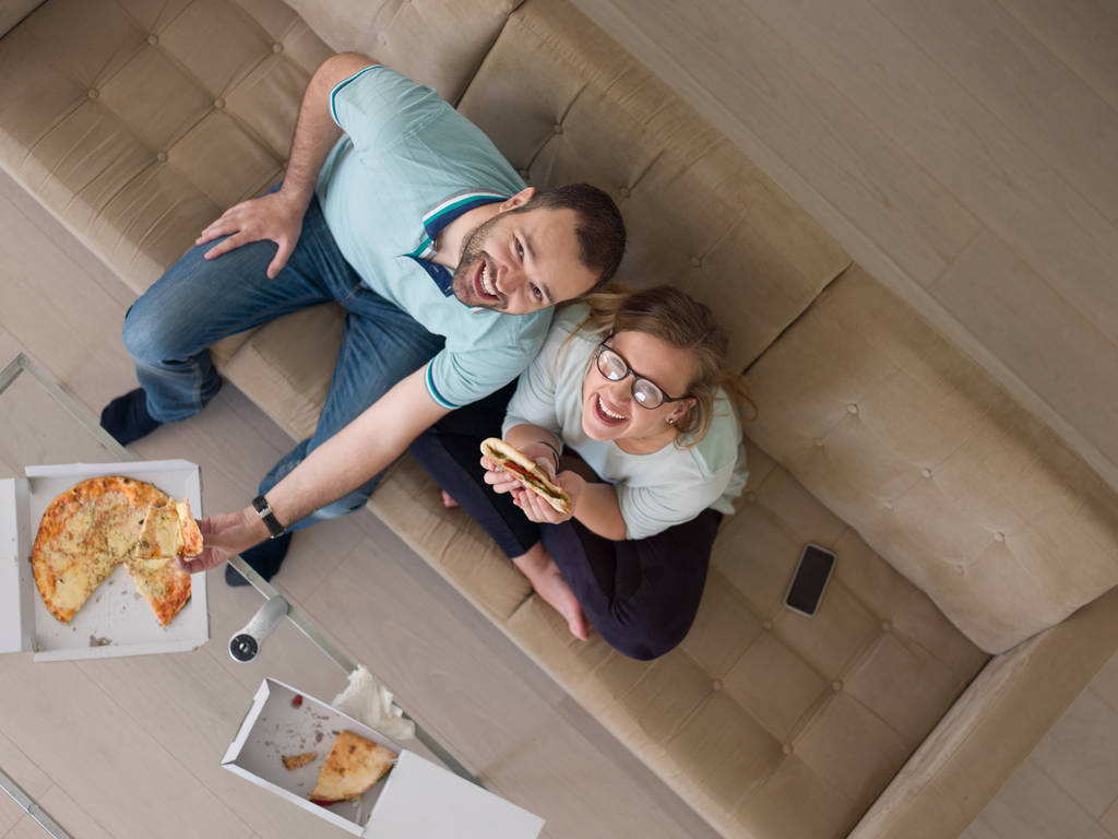 casal comer pizza em sua casa de luxo
 - Foto, Imagem