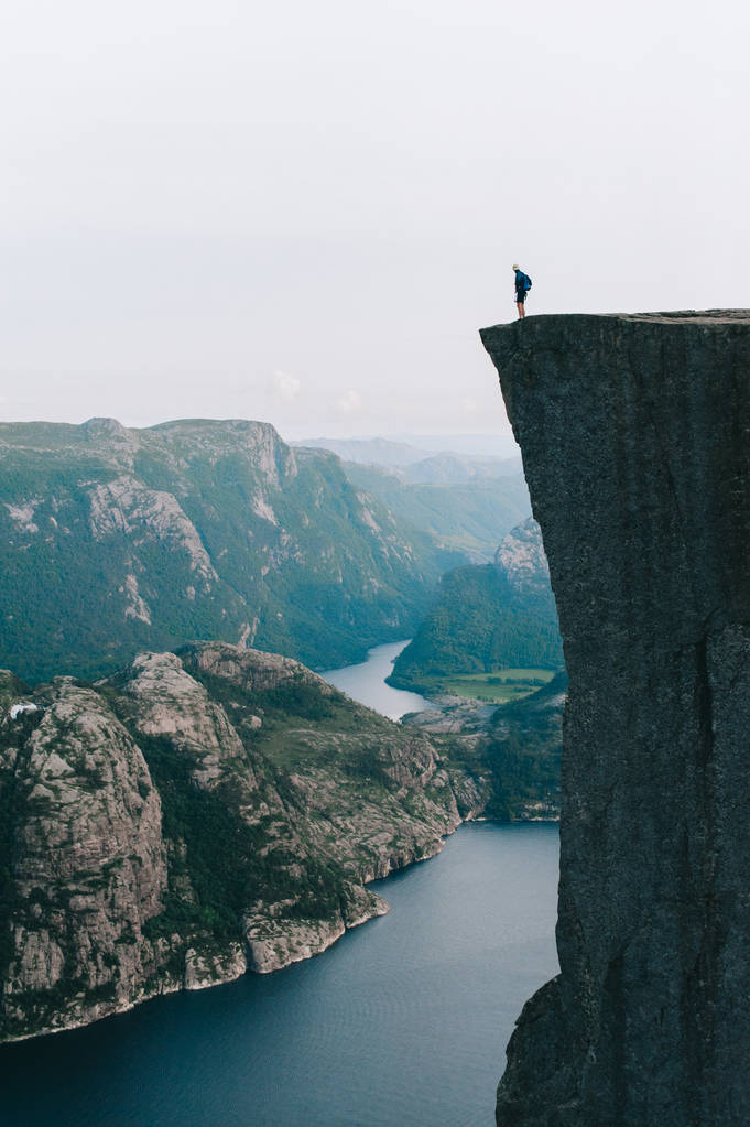 Preikestolen、ノルウェーの端に立っている男性 - 写真・画像