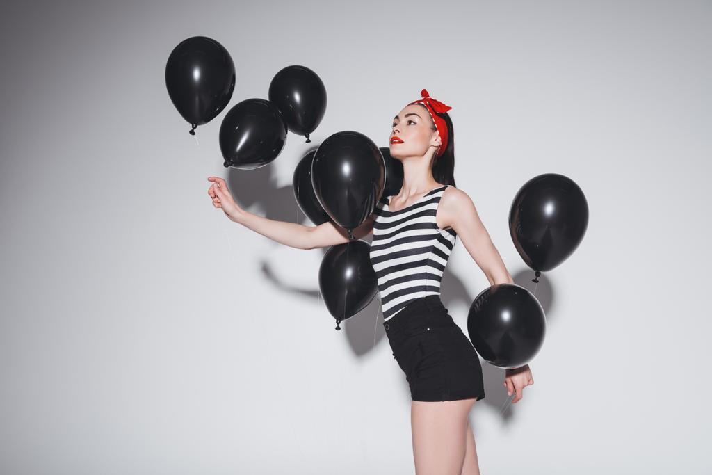 Mujer con estilo con globos negros
 - Foto, imagen