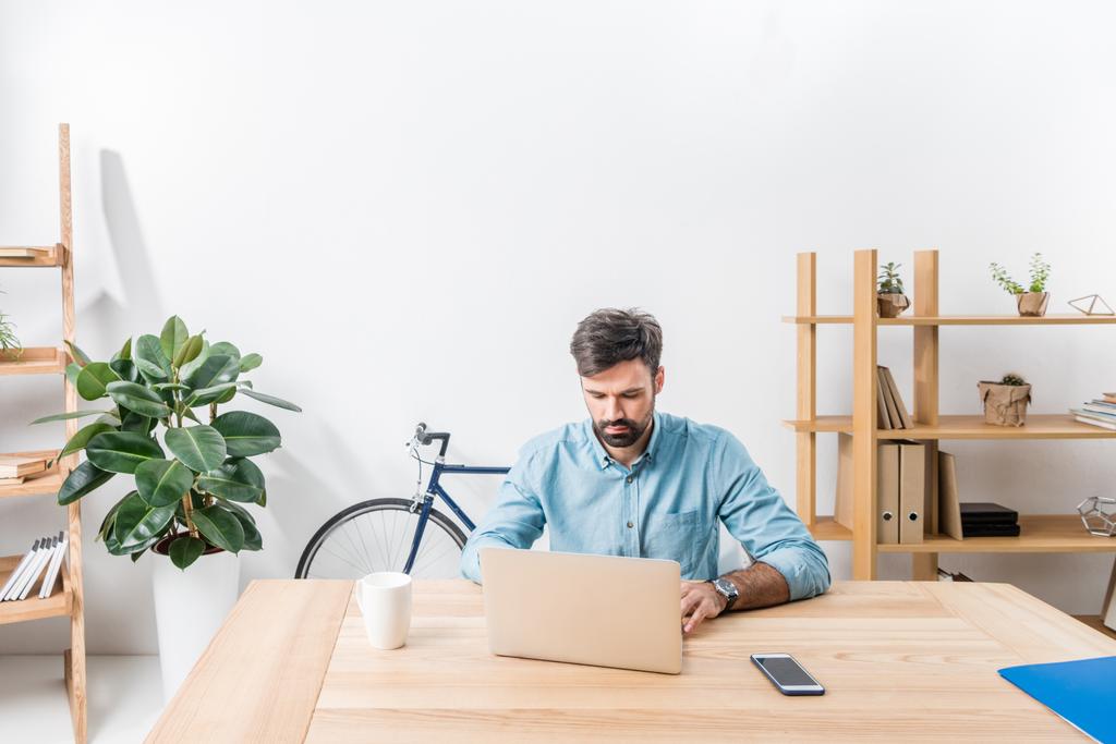 бизнесмен работает с ноутбуком в офисе - Фото, изображение