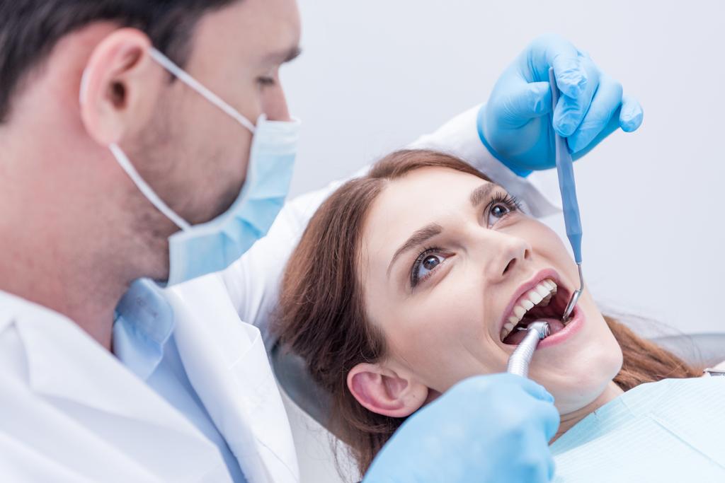Οδοντίατρος που θεραπεύει δόντια ασθενών - Φωτογραφία, εικόνα