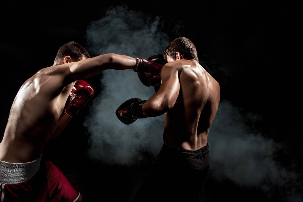 Dos boxeadores profesionales boxeando sobre fondo ahumado negro
, - Foto, Imagen