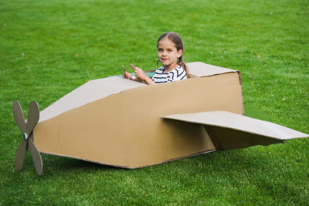 Meisje speelt met vliegtuig in park - Foto, afbeelding
