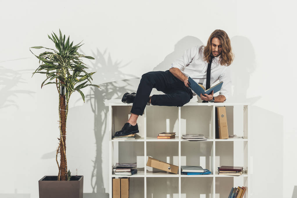 Üzletember hazudik bookshelf a - Fotó, kép