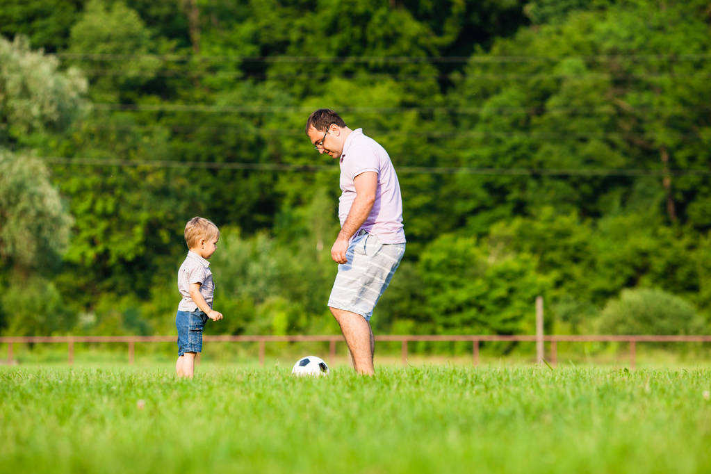 Отец и сын играют в футбол - Фото, изображение