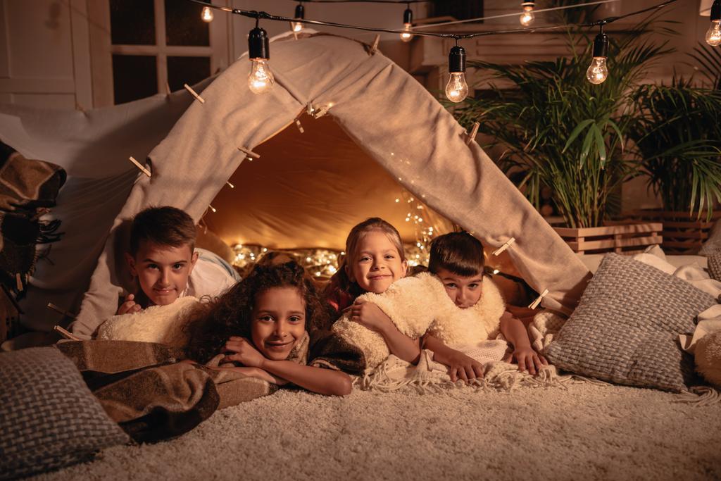 enfants multiculturels reposant dans une tente à la maison
 - Photo, image