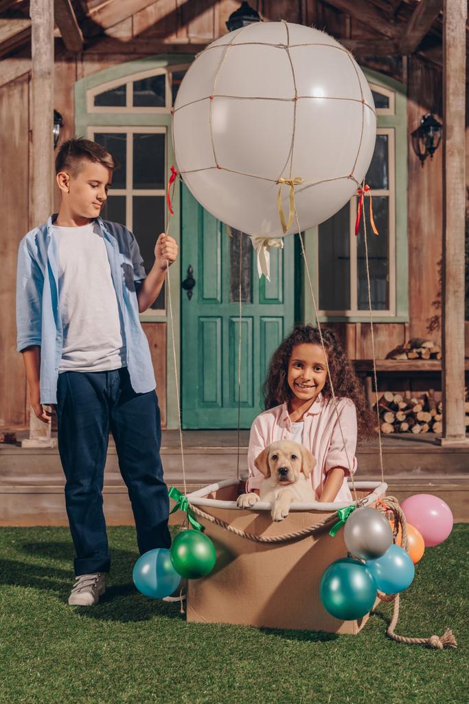 chica con cachorro en globo de aire caja
 - Foto, Imagen