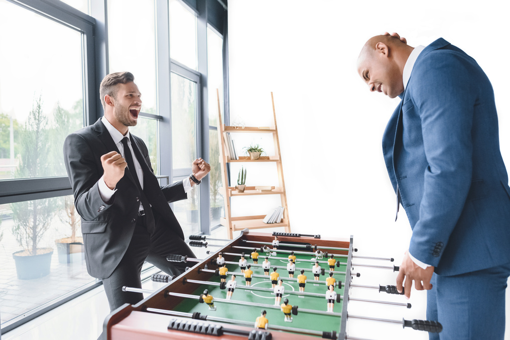 Бизнесмены играют в настольный футбол
 - Фото, изображение