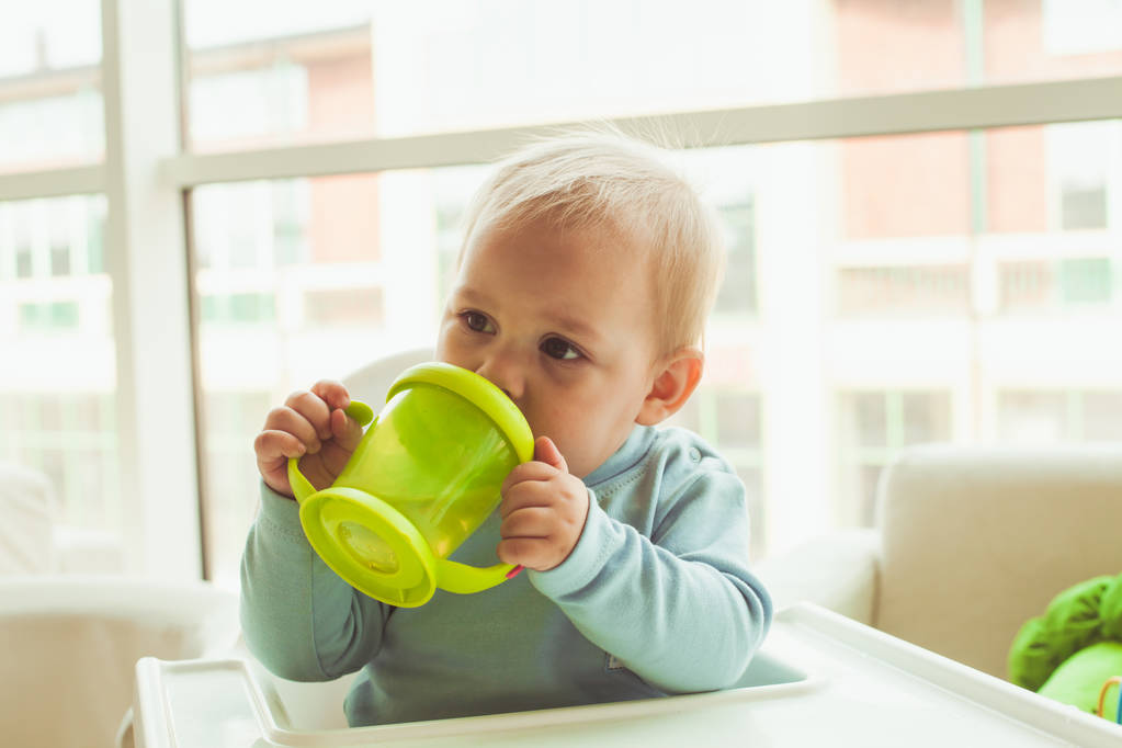 Niño pequeño con taza de bebé
 - Foto, imagen