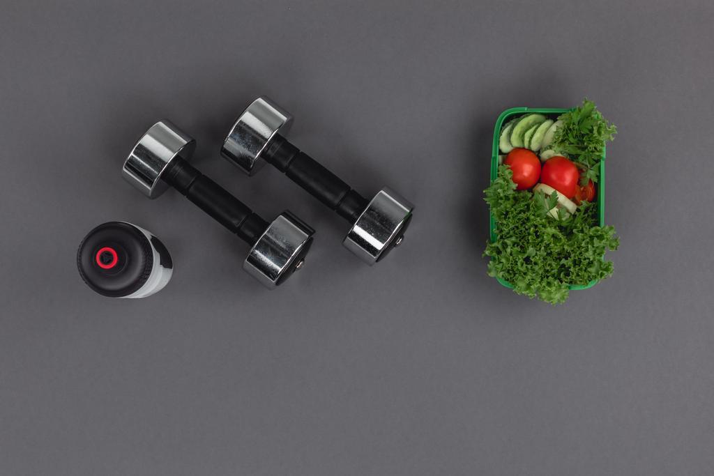 Dumbbells with sports bottle and salad - Photo, Image