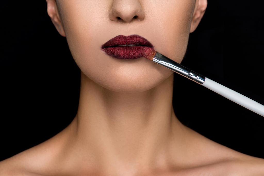 vrouw toepassen van donkere lippenstift  - Foto, afbeelding