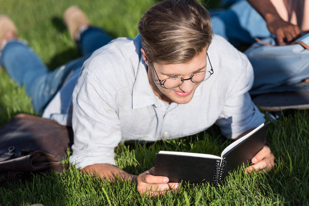 Man reading textbook in park - Photo, Image