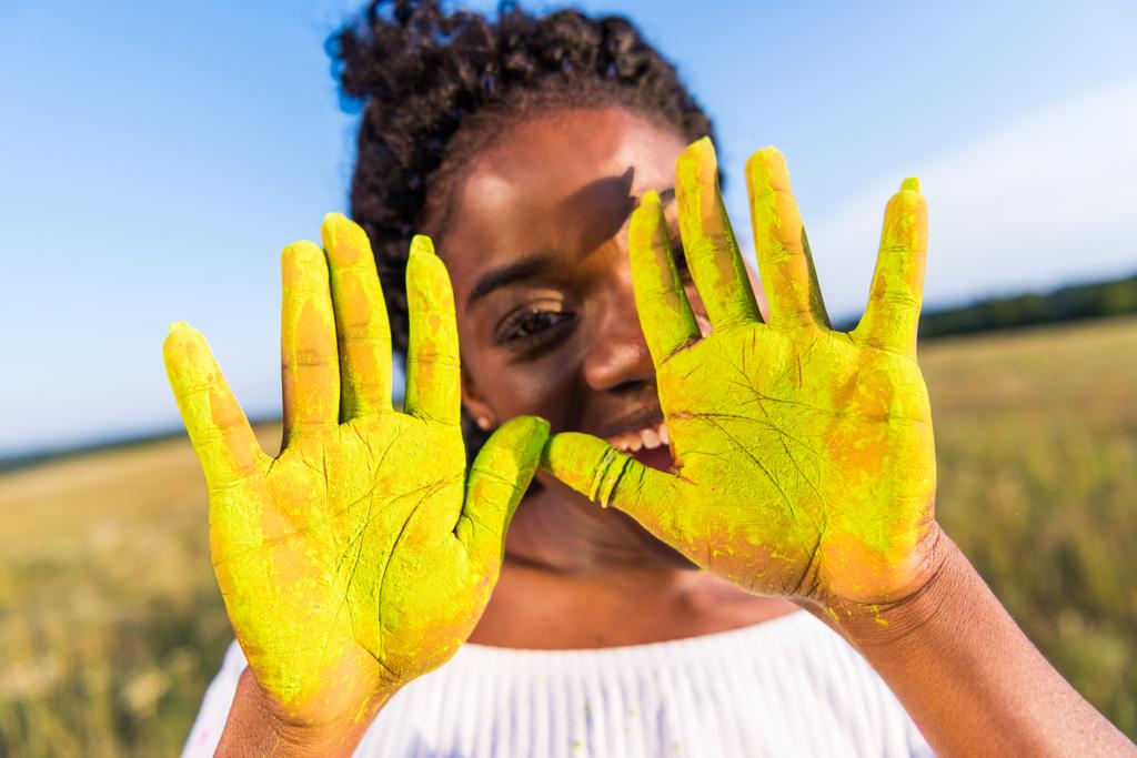 Mädchen mit gelber Farbe auf Handflächen - Foto, Bild