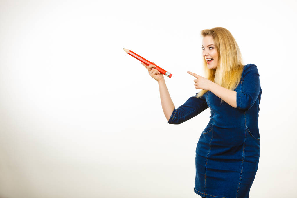Позитивная женщина держит большой карандаш в руке
 - Фото, изображение