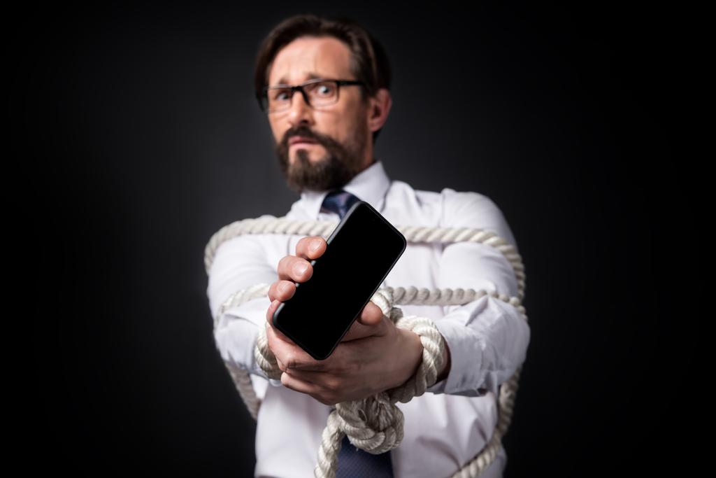 homem de negócios amarrado segurando smartphone
 - Foto, Imagem