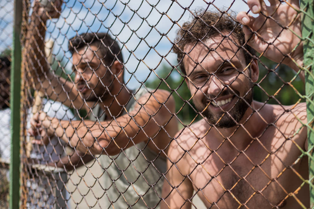 hommes penchés sur la clôture
  - Photo, image