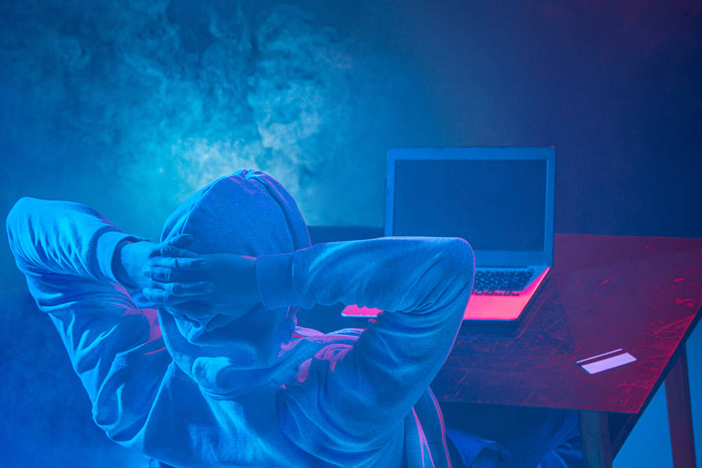 Hooded tietokone hakkeri varastaa tietoja kannettavan - Valokuva, kuva