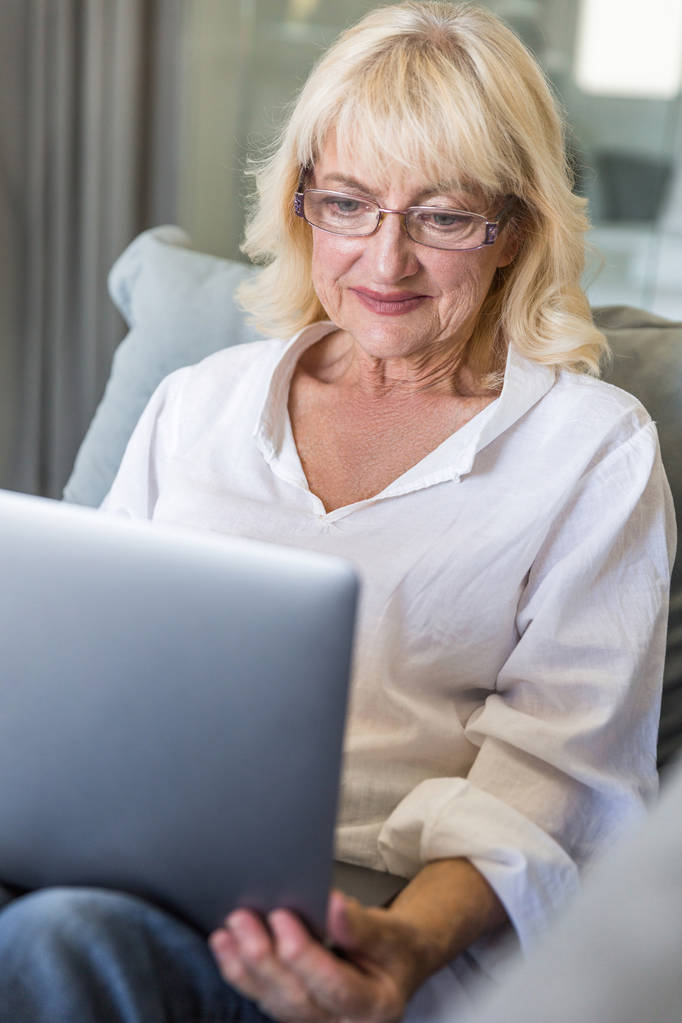 Senior woman in eyeglasses using laptop computer - Photo, Image